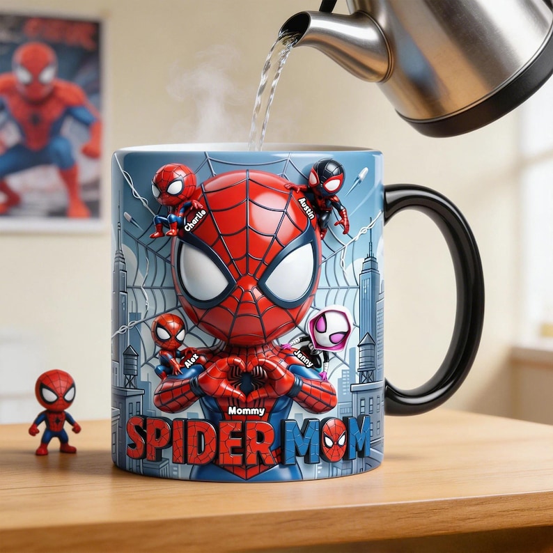 May include: A ceramic Spider-Man mug with a black handle, featuring a 3D Spider-Man design and the words "Spider Mom." The mug is personalized with names and surrounded by a cityscape background. A small Spider-Man figurine is next to the mug.