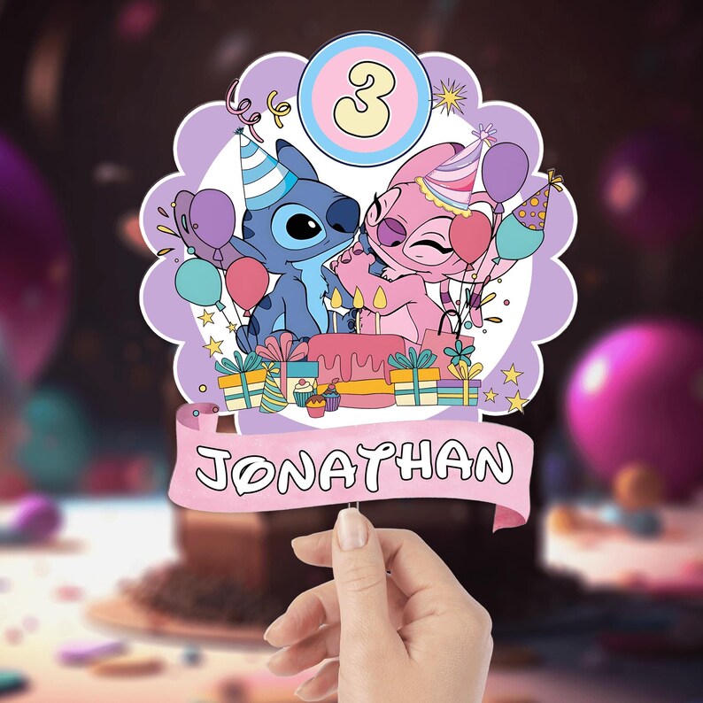 Może przedstawiać: Topper na tort urodzinowy z postaciami Stitcha i Angel, balonami, prezentami i ciastem. Wyświetlana jest liczba 3 wraz z imieniem "Jonathan" na banerze. Topper jest trzymany przez dłoń.