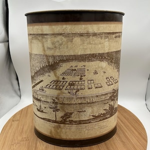 May include: A white ceramic mug with a black handle and the text "But First, Coffee" in a bold, black font. The mug is sitting on a wooden surface. The mug is 4 inches tall.