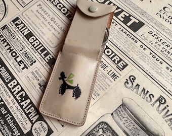 Estuche de tocador de cuero vintage de los años 50 con diseño de caniche, espejo, peine, tijeras y lima de uñas.
