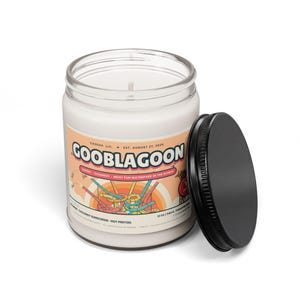 Gooblagoon candle with the black lid off, showing white paraffin wax and a single cotton wick