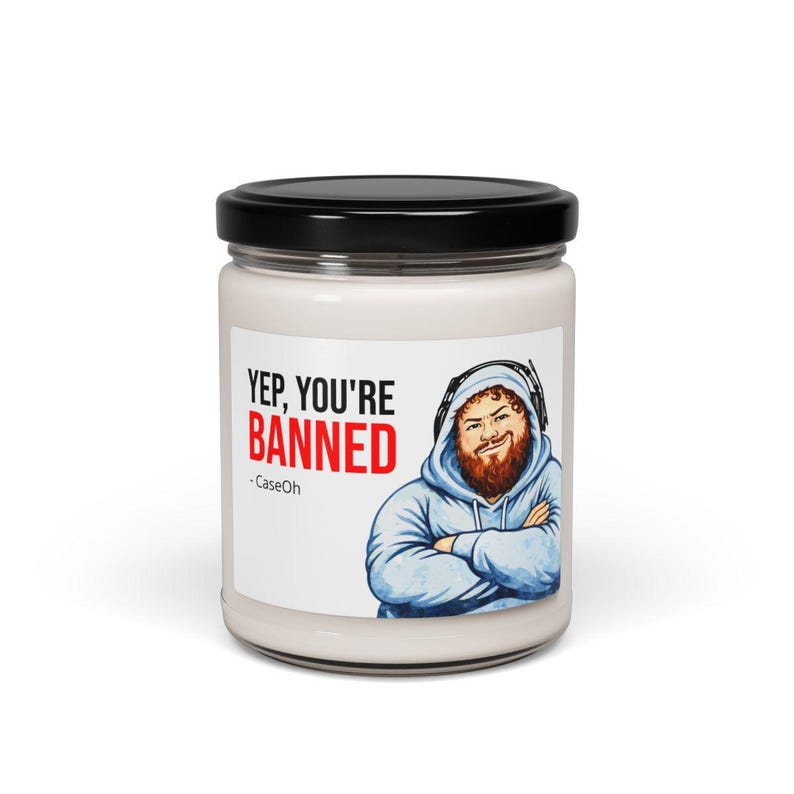 CaseOh Yep You're Banned candle, 12 oz paraffin meme candle in a glass jar with a black lid, front view on white