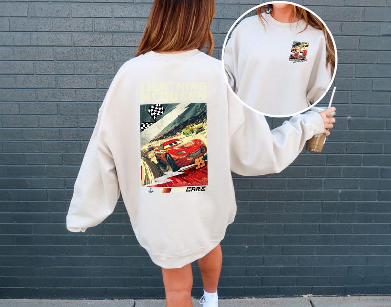 Puede incluir: Sudadera color crema con un dise&ntilde;o de Rayo McQueen de la pel&iacute;cula Cars. El dise&ntilde;o incluye el n&uacute;mero 95, una bandera a cuadros y la palabra "CARS". Una versi&oacute;n m&aacute;s peque&ntilde;a del dise&ntilde;o est&aacute; en la parte delantera.