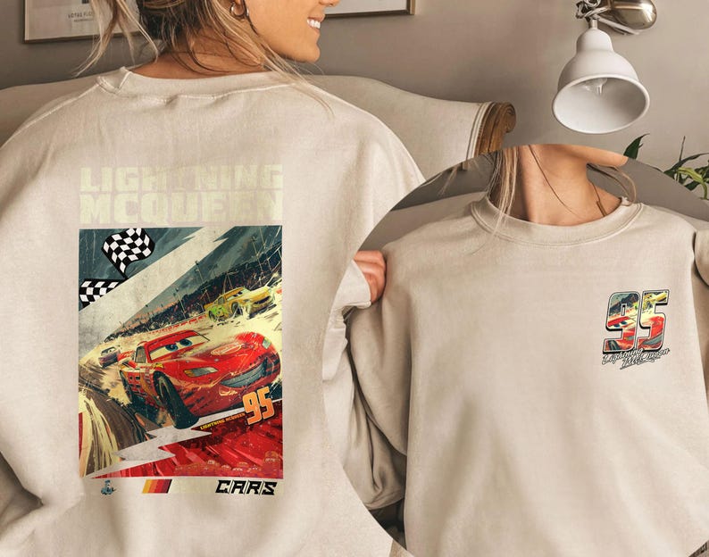 Puede incluir: Sudadera beige con un gr&aacute;fico de Rayo McQueen de la pel&iacute;cula Cars. El gr&aacute;fico frontal muestra una escena de carrera con el n&uacute;mero 95. La parte posterior de la sudadera tiene un gr&aacute;fico m&aacute;s peque&ntilde;o del n&uacute;mero 95.