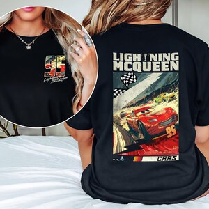 Puede incluir: Camiseta negra con Lightning McQueen de la pel&iacute;cula Cars. La parte delantera tiene un peque&ntilde;o gr&aacute;fico del n&uacute;mero 95 y el nombre del personaje. La parte trasera muestra una imagen m&aacute;s grande de Lightning McQueen corriendo, con el texto "LIGHTNING MCQUEEN".