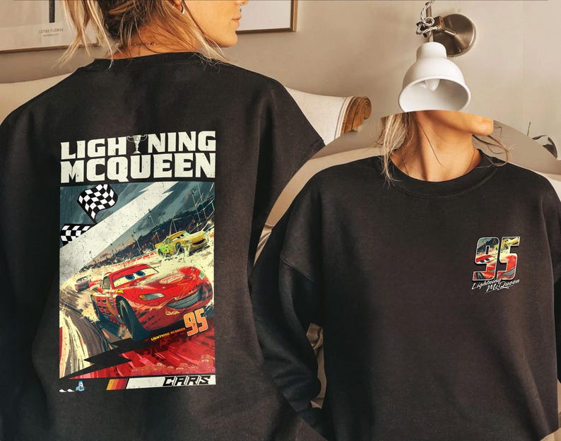 Puede incluir: Sudadera negra con un gr&aacute;fico de Rayo McQueen de la pel&iacute;cula Cars. La parte trasera muestra una escena de carreras con el n&uacute;mero 95. La parte delantera tiene el n&uacute;mero 95 y el nombre de Rayo McQueen.