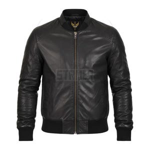 May include: Black leather bomber jacket with a quilted design on the shoulders and sleeves. The jacket features a ribbed collar, cuffs, and hem, and a full-length zipper. The jacket has a small logo on the chest.
