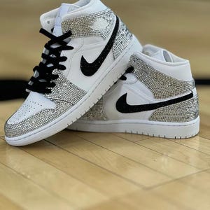 Zapatillas de lujo Air Jordan 1 Mid blancas personalizadas con cristales plateados y acabado cristalizado a mano.