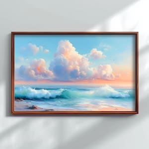 May include: A framed painting of a coastal scene. The artwork shows turquoise waves breaking on a sandy shore beneath a sky filled with fluffy, peach-coloured clouds. The frame is a warm, dark brown.
