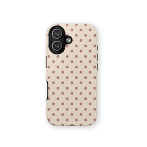 May include: A phone case with a cream-colored background and a pattern of evenly spaced, small, mauve-colored polka dots. The case has a black camera module and black side buttons.