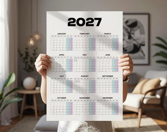 May include: A vertical wall calendar for the year 2027 printed on a white sheet. The calendar features twelve monthly grids arranged in four rows of three, with bold black text for the year at the top and month names above each grid.