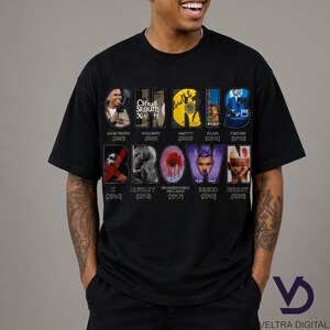 Puede incluir: Camiseta negra con el nombre "CHRIS BROWN" en un dise&ntilde;o colorido y estilizado. El dise&ntilde;o incorpora portadas de &aacute;lbumes y t&iacute;tulos, incluyendo "X", "Royalty" e "Indigo". La camiseta tiene cuello redondo y mangas cortas.