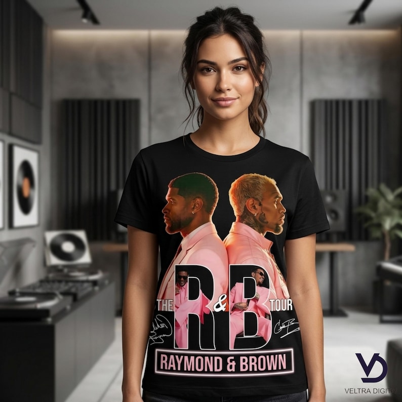 Puede incluir: Camiseta negra con un gr&aacute;fico de dos hombres con trajes rosas, con el texto "THE RB TOUR" y "RAYMOND & BROWN". El dise&ntilde;o incluye firmas y un logotipo. La camiseta la lleva una persona.