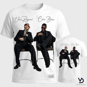 Puede incluir: Camiseta blanca con un gr&aacute;fico de dos hombres con trajes negros, sentados en sillas. Los nombres "Usher Raymond" y "Chris Brown" est&aacute;n escritos encima de la imagen en plata. Una versi&oacute;n m&aacute;s peque&ntilde;a del gr&aacute;fico est&aacute; en la parte posterior.