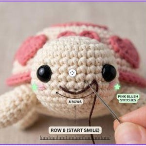 May include: A cream-colored crochet turtle with a pink shell, black safety eyes, and pink blush stitches. A needle pulls dark brown yarn to form a smile. Text labels indicate 8 rows, pink blush stitches, and row 8 start smile.