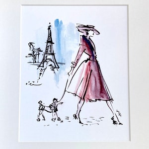 May include: A black and white ink illustration of a woman in a pink dress and hat walking a small dog in front of the Eiffel Tower.