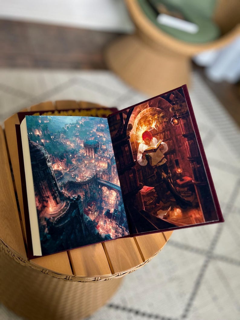 Pode incluir: Um livro aberto com ilustra&ccedil;&otilde;es de fantasia. Uma p&aacute;gina mostra uma cidade com luzes, a outra uma pessoa lendo em uma biblioteca. O livro tem uma capa bord&ocirc; e est&aacute; em uma mesa de madeira.