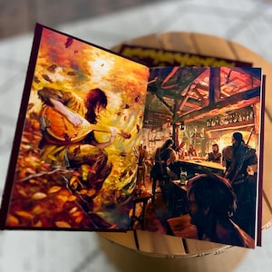 Pode incluir: Livro aberto com ilustra&ccedil;&otilde;es de fantasia. Uma p&aacute;gina mostra uma pessoa tocando ala&uacute;de em uma floresta com folhas de outono. A outra p&aacute;gina mostra uma cena de taberna com pessoas no bar.