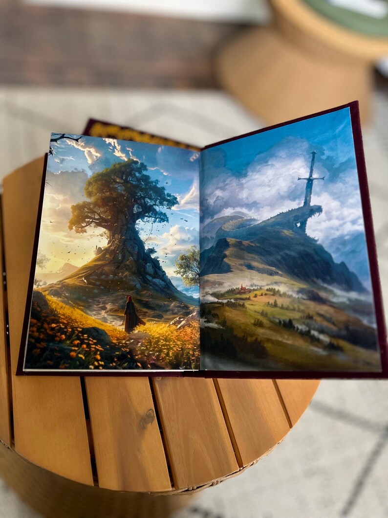 Pode incluir: Um livro aberto com duas ilustra&ccedil;&otilde;es de paisagens. Uma mostra uma pessoa em frente a uma grande &aacute;rvore numa colina, a outra uma espada numa montanha. O livro tem uma capa bord&ocirc; e est&aacute; numa mesa de madeira.