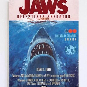 Puede incluir: Un póster con el título de la película "JAWS" en rojo, y las palabras "RELENTLESS PREDATOR" debajo. La imagen muestra un tiburón emergiendo del agua, con un nadador en la superficie. El texto incluye "LEGENDARY CREATURE SHARK".