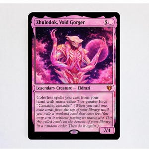 Puede incluir: Una carta coleccionable Zhulodok, Void Gorger con un fondo cósmico rosa y morado y una criatura Eldrazi central. El texto de la carta dice Colorless spells you cast from your hand with mana value 7 or greater have Cascade, cascade.