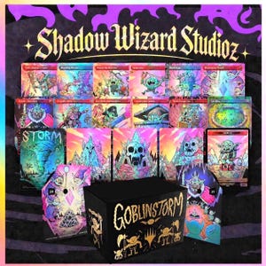 May include: A collection of fantasy trading cards and a black box with the text "Goblinstorm" in gold. The cards feature colorful illustrations of goblins and fantastical creatures. The background is a vibrant mix of purple, pink, and yellow.