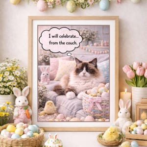 May include: A framed print showing a cat relaxing on a couch, with Easter decorations. The cat's thought bubble says, "I will celebrate... from the couch." The image includes Easter eggs, bunnies, and flowers, creating a festive atmosphere.