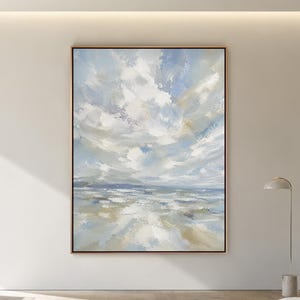 May include: A large rectangular wall art piece featuring an abstract landscape painting with thick, textured brushstrokes in shades of light blue, white, and soft beige, framed in a thin, simple wooden border, hanging on a plain white wall.