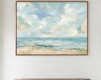 Puede incluir: Pintura abstracta de un paisaje de playa con cielo azul y océano. La obra presenta pinceladas azules, blancas y beige, enmarcada en un marco de madera marrón. Debajo del cuadro hay un banco de madera rústico.