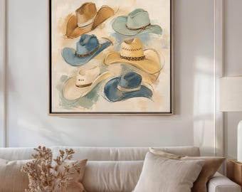 Puede incluir: Una obra de arte enmarcada que presenta una colección de sombreros de vaquero en varios colores, incluyendo marrón, azul y crema. Los sombreros están pintados con pinceladas suaves, creando una estética rústica y artística. La obra se exhibe sobre un sofá beige.