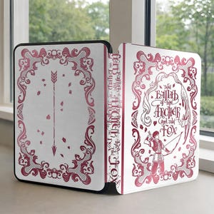 Puede incluir: Una cubierta de libro blanca con un diseño de flecha roja y el título "The Ballad of the Archer and the Fox". La cubierta tiene un borde decorativo y el título se muestra verticalmente en el lomo. El libro está abierto.