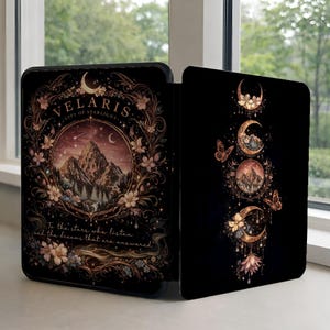Peut inclure: Étui noir en forme de livre avec un design céleste. Le côté gauche présente le texte "VELARIS CITY OF STARLIGHT" et une scène de montagne. Le côté droit présente un motif vertical de lunes, de papillons et d'éléments floraux.