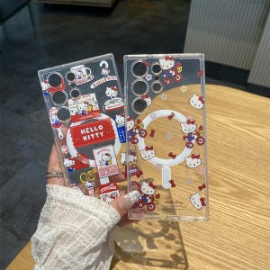 May include: Clear phone cases featuring Hello Kitty designs. One case has a large Hello Kitty label and various themed stickers. The other case has Hello Kitty riding a bicycle and other Hello Kitty graphics. Both cases are transparent.