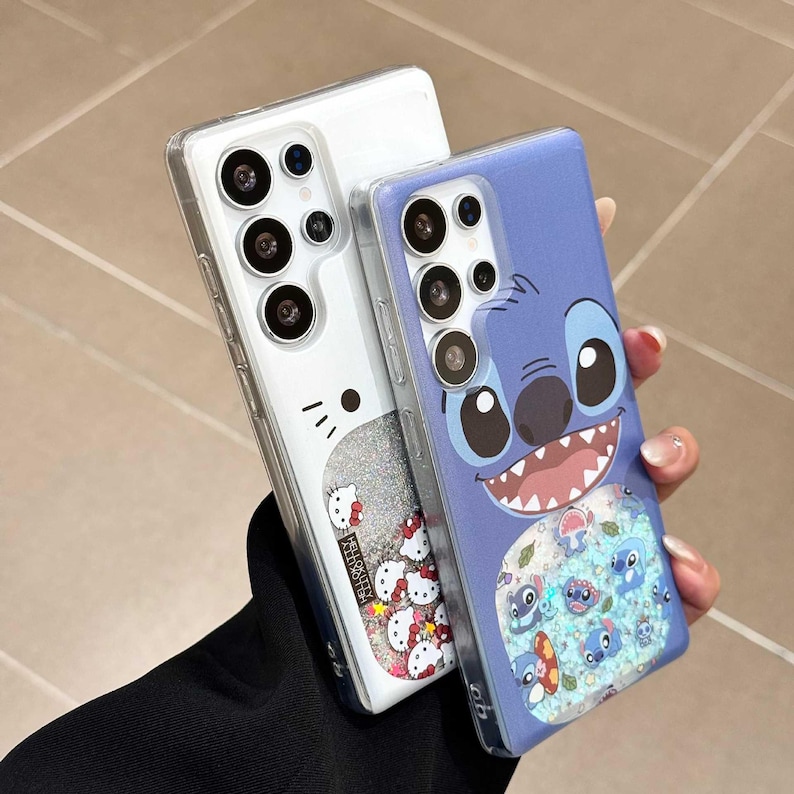 May include: Two phone cases. One is clear with a Hello Kitty design and glitter. The other is blue with a Stitch character design and glitter. Both cases have a clear border and are designed for a smartphone.
