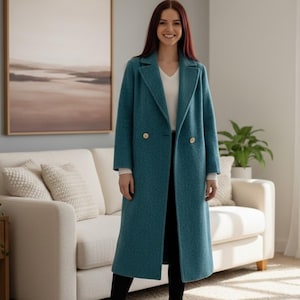 Peut inclure: Un manteau bleu sarcelle à double boutonnage avec des boutons dorés. Le long manteau a un revers classique et est porté sur un haut blanc et un pantalon noir. Un vêtement d'extérieur élégant.