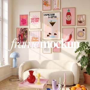 May include: A gallery wall arrangement of eleven framed art prints featuring pink backgrounds, illustrations of food, drinks, and text including Espresso Martini, Ciao Bella, and Hot Girl Sauce, displayed above a cream-colored curved sofa.