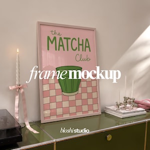 Może przedstawiać: Prostokątny plakat w jasnoróżowej ramie z napisem "the MATCHA Club" zielonymi literami nad ilustracją zielonego kubka na różowo-białym tle w kratkę. Plakat znajduje się na zielonej powierzchni.