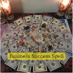 Op de afbeelding: Een weergave van Amerikaanse $100-biljetten gerangschikt in een cirkelvormig patroon, met kristallen, een kaneelstokje en kaarsen. De tekst "Business Success Spell" wordt weergegeven op een gele banner.