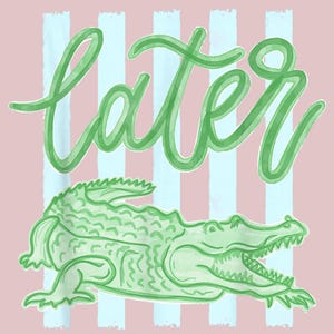 Peut inclure: Illustration d'un alligator vert avec le mot "later" en écriture cursive. Le design est posé sur un fond rose avec des rayures verticales bleu clair. L'alligator a la gueule ouverte.
