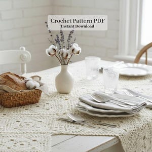 May include: A dining table set for a meal, featuring a cream-colored crocheted tablecloth. The table is set with white plates, silverware, and clear glasses. A basket of bread and a vase of flowers add to the setting. Text on the image reads: Crochet Pattern PDF Instant Download.