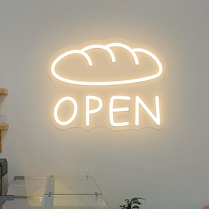 May include: A rustic wooden sign with the text "Welcome to our home" in white lettering. The sign features a distressed finish and a simple, inviting design, perfect for entryway decor.