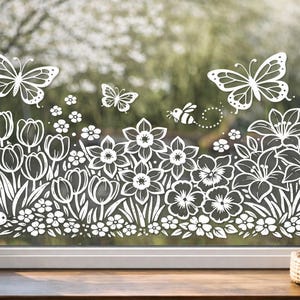 May include: White floral and butterfly window decal. The design features detailed illustrations of tulips, daffodils, butterflies, and a bee. The decal is applied to a window, creating a decorative garden scene.
