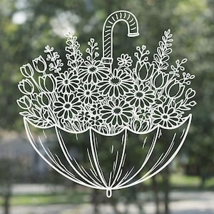 Könnte beinhalten: Weißes Strichkunst-Design eines Regenschirms, gefüllt mit verschiedenen Blumen, darunter Gänseblümchen und Tulpen. Der Regenschirmgriff ist nach oben gebogen, und die Blumen quellen heraus. Das Design befindet sich vor einem verschwommenen grünen Hintergrund.