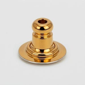Op de afbeelding: Een goudkleurige flesstopper met een afgeronde bovenkant en een cirkelvormige basis. De stopper heeft een glanzende, metallic afwerking en een eenvoudig ontwerp. De basis heeft een zilveren rand.