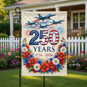 May include: A garden flag with a patriotic design. It features blue fighter jets, fireworks, and the text "250 YEARS 1776-2026" in red, white, and blue. A floral wreath of red, white, and blue flowers surrounds the text.