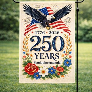 May include: A garden flag featuring an American flag design with an eagle and the text "1776-2026 250 YEARS Semiquincentennial." The flag is decorated with red, white, and blue flowers and is displayed on a black metal stand.