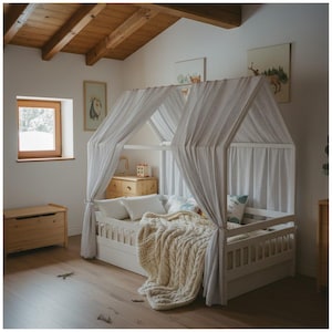 May include: A white wooden house bed with a striped canopy and a cream-colored cable knit blanket. The bed is in a child's bedroom with wooden floors, a wooden chest, and artwork on the walls. The bed frame is approximately 75 inches long.