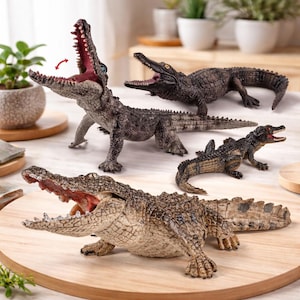 May include: Several crocodile figurines in different poses and sizes. The models are predominantly brown and grey, with open mouths showing red interiors. Some are standing, while others are lying down on a wooden surface.