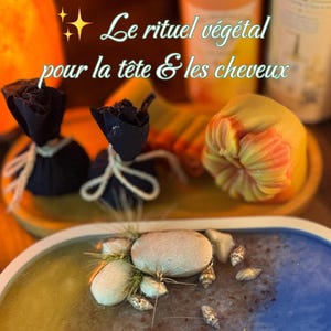 Puede incluir: Una bandeja rectangular con superficie en degradado azul y amarillo, decorada con pequeñas conchas, piedras y plantas de aire. Detrás hay dos bolsas de tela negra atadas con cuerda, un objeto amarillo en forma de flor y dos botellas con etiquetas.