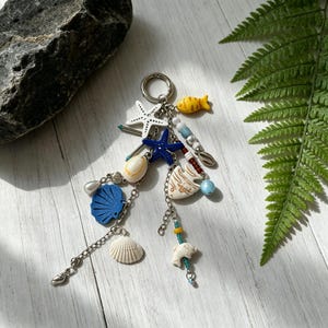 Llavero con temática oceánica / Adorno para bolso con estrellas de mar, conchas, peces y delfines